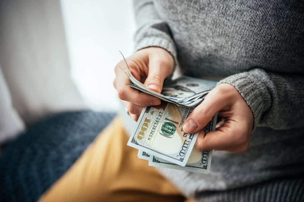 Hands holding hundreds of dollars